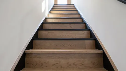 Schody jesionowe z czarnymi podstopniami